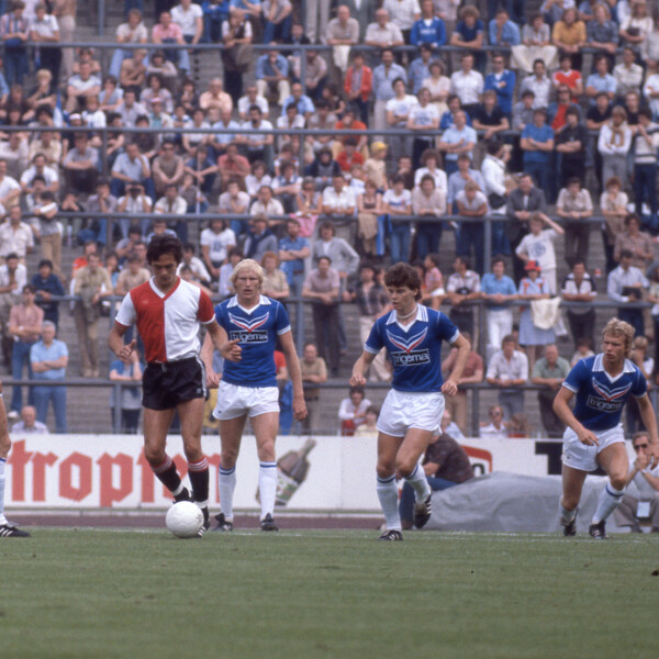 Ein Spieler von Feyernoord Rotterdamm dribbelt vier Spieler des FC Schalke 04 vor einer vollen Tribüne aus.
